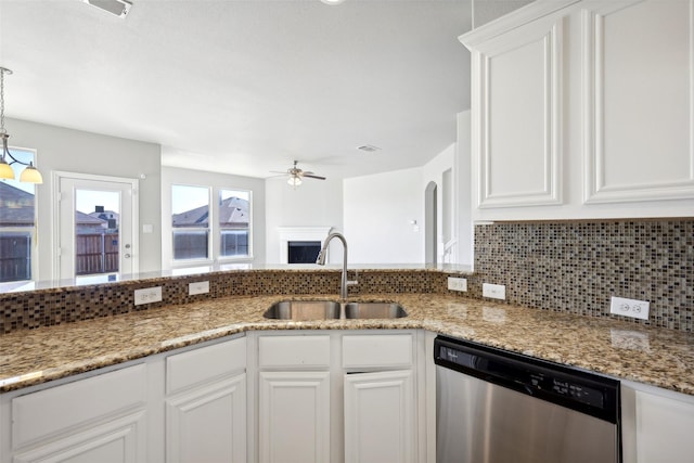 kitchen with dishwasher, white cabinets, sink, ceiling fan, and light stone counters