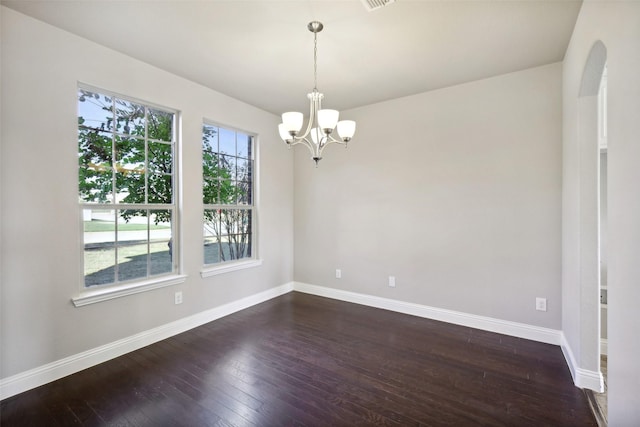 unfurnished room featuring dark hardwood / wood-style floors and a chandelier