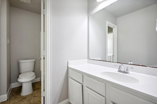 bathroom with tile patterned flooring, vanity, and toilet