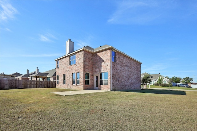 rear view of house featuring a patio area and a lawn