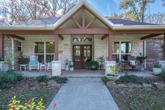 entrance to property with a porch and french doors