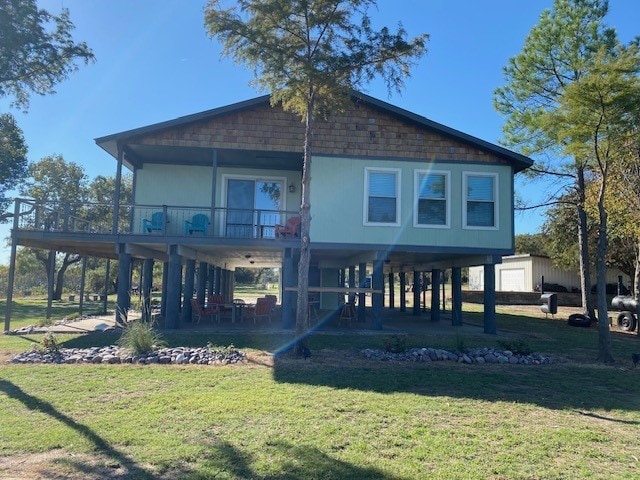 rear view of property featuring a lawn