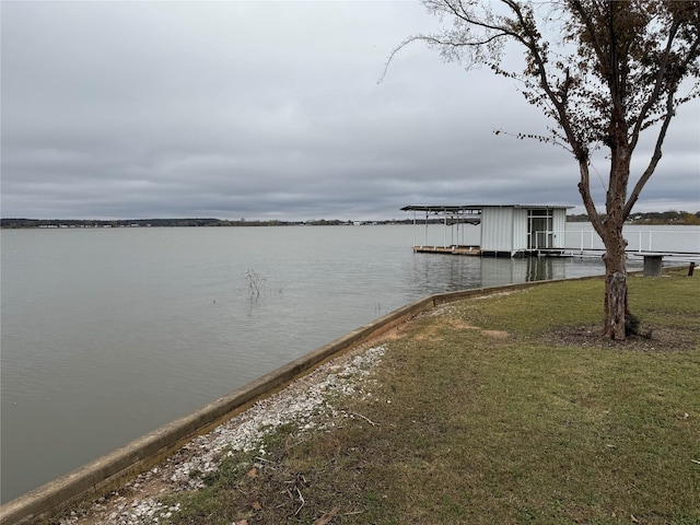 view of dock featuring a water view and a yard