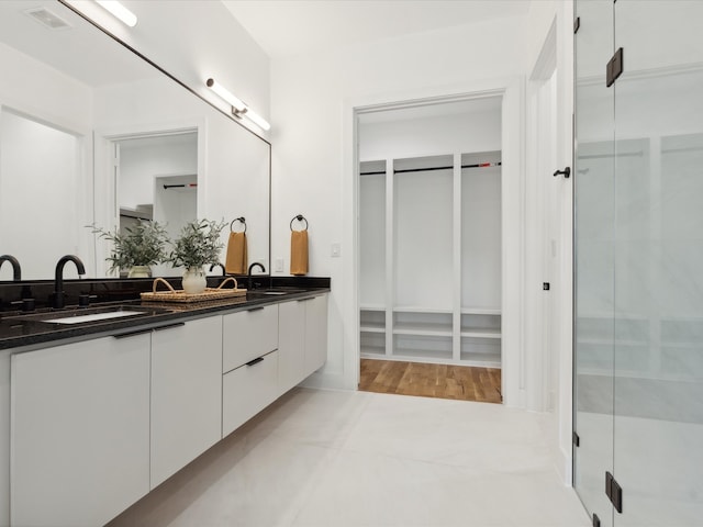 bathroom featuring hardwood / wood-style floors, vanity, and a shower with shower door