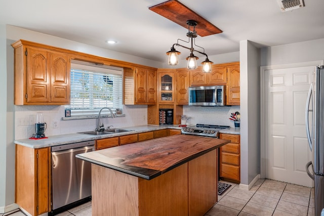 kitchen featuring tasteful backsplash, sink, a kitchen island, and stainless steel appliances