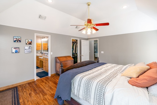 bedroom featuring ceiling fan, ensuite bathroom, light hardwood / wood-style floors, a walk in closet, and a closet