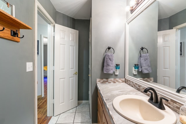 bathroom featuring hardwood / wood-style flooring, vanity, and tasteful backsplash