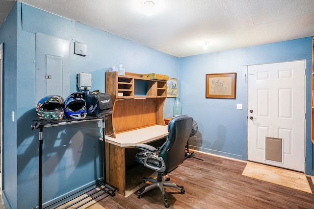 office featuring electric panel, baseboards, and wood finished floors