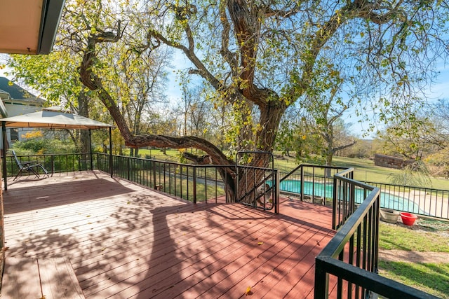 deck featuring a fenced in pool, fence, and a gazebo