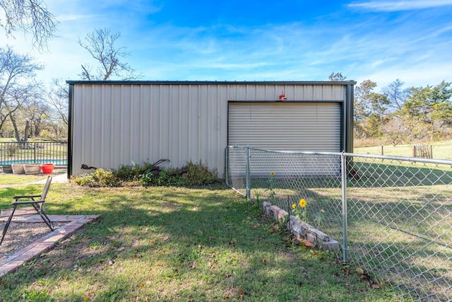 view of outbuilding featuring driveway, an outdoor structure, and fence