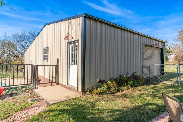 view of outdoor structure with fence and an outbuilding