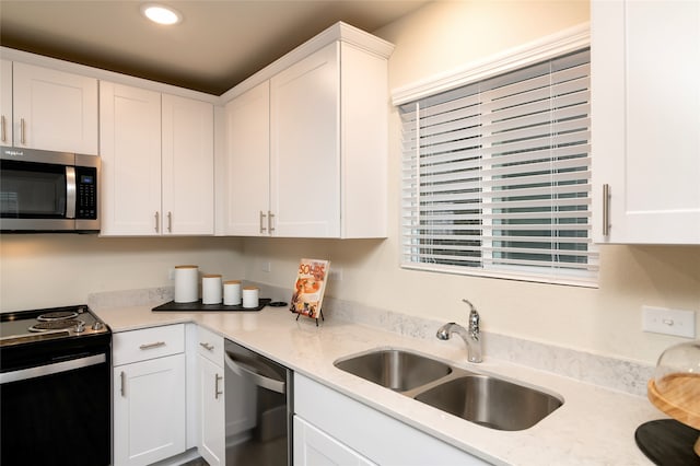 kitchen featuring white cabinets, light stone countertops, sink, and appliances with stainless steel finishes