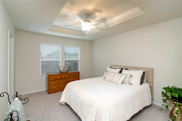 carpeted bedroom with a raised ceiling and ceiling fan