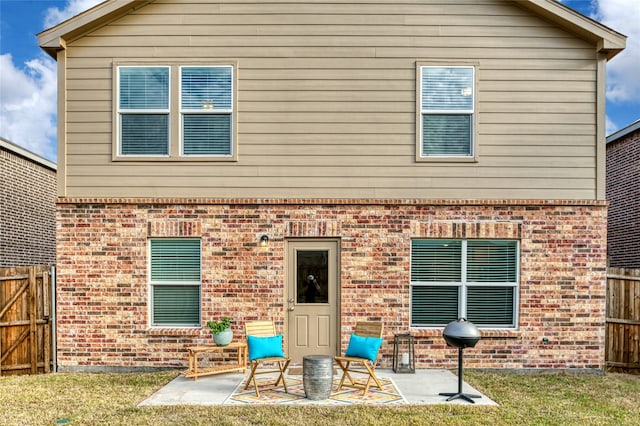 back of property with a patio area and a yard