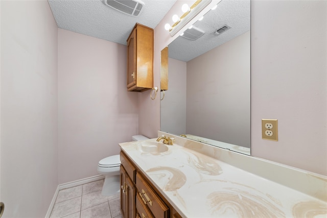 bathroom featuring toilet, vanity, a textured ceiling, and tile patterned floors