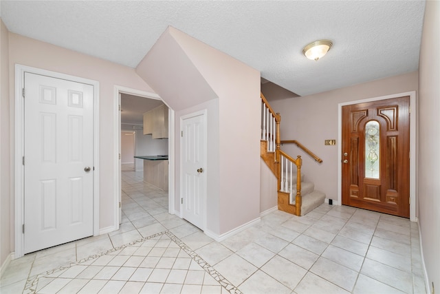 tiled entrance foyer featuring a textured ceiling