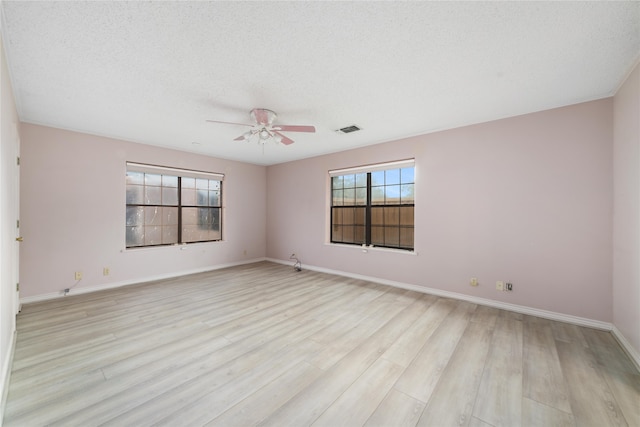 unfurnished room featuring light hardwood / wood-style floors and a textured ceiling