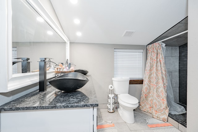 bathroom featuring tile patterned floors, toilet, vanity, and walk in shower