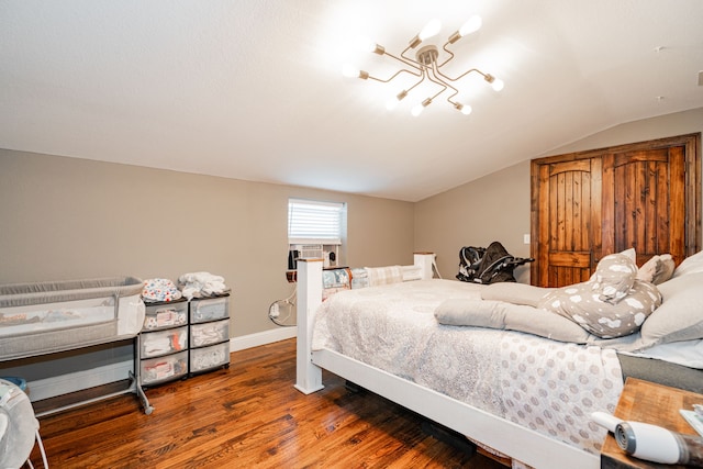 bedroom with a chandelier, dark hardwood / wood-style flooring, and lofted ceiling