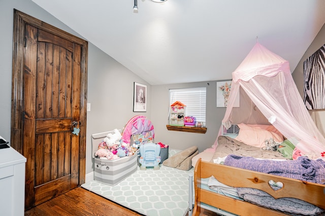 bedroom with hardwood / wood-style floors and vaulted ceiling