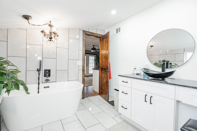 bathroom with vanity, tile patterned floors, vaulted ceiling, a washtub, and ceiling fan