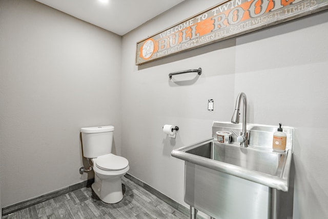 bathroom featuring wood-type flooring, sink, and toilet