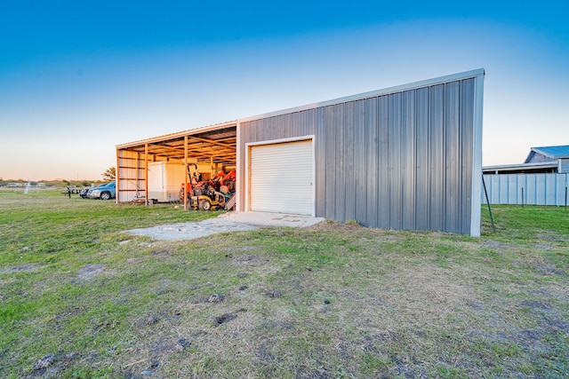 outdoor structure at dusk featuring a yard