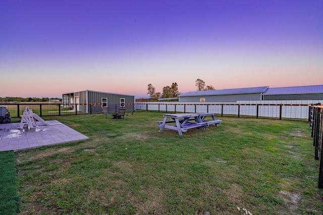 yard at dusk featuring a patio area