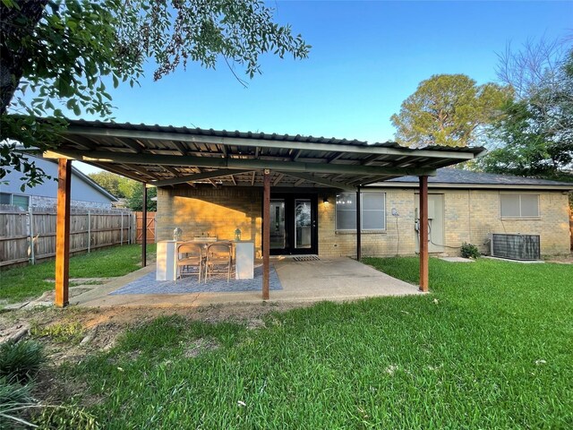 rear view of house featuring a lawn, a patio area, and central AC unit