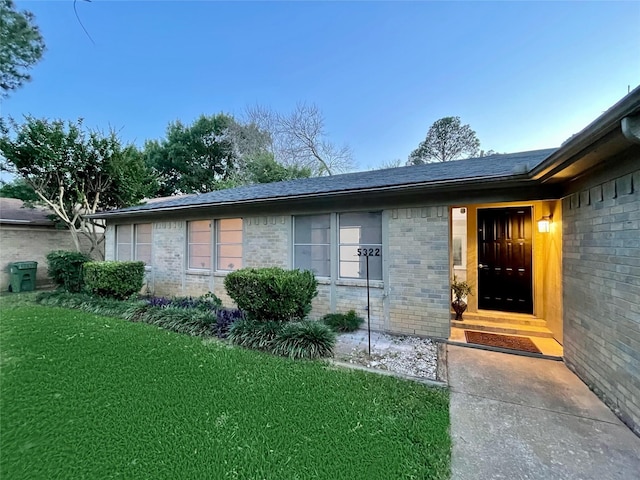 doorway to property featuring a lawn