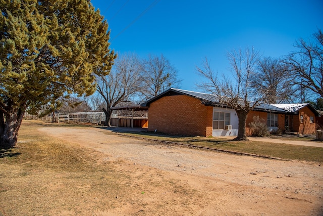 view of home's exterior featuring brick siding and a lawn