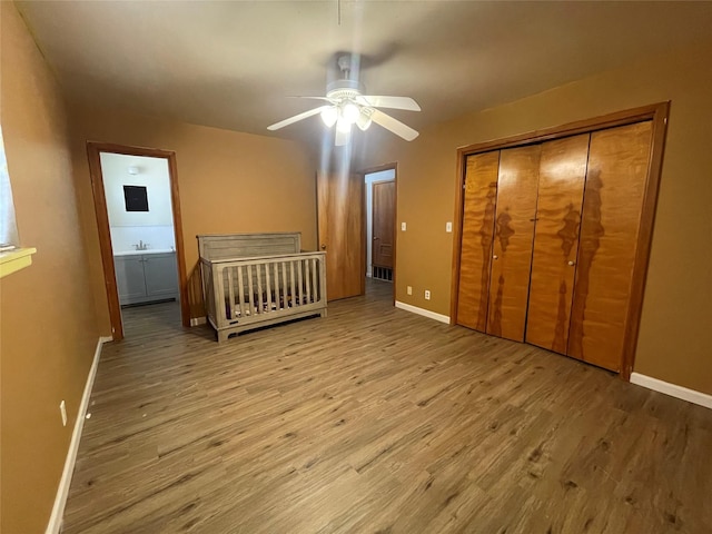 unfurnished bedroom featuring sink, light hardwood / wood-style flooring, a closet, and ceiling fan