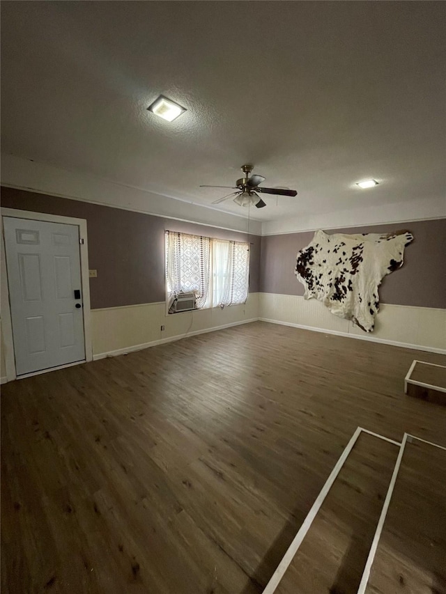 interior space featuring cooling unit, ceiling fan, and dark hardwood / wood-style floors