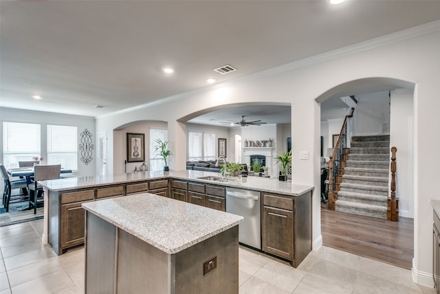 kitchen with kitchen peninsula, a center island, stainless steel dishwasher, and ceiling fan