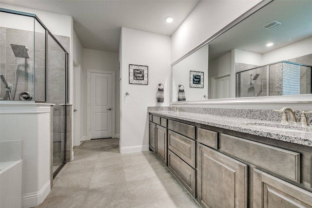 bathroom featuring tile patterned flooring, vanity, and a shower with door