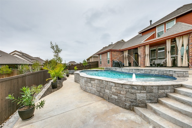 view of pool with a patio area and pool water feature