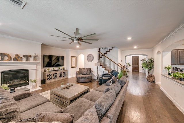 living room with dark hardwood / wood-style floors, ceiling fan, and crown molding