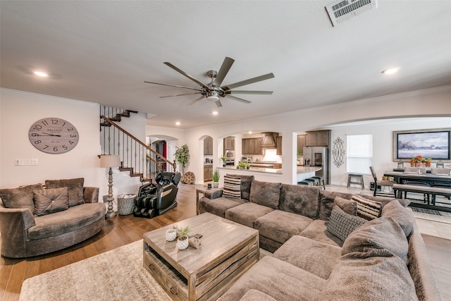 living room with crown molding, ceiling fan, and light hardwood / wood-style floors