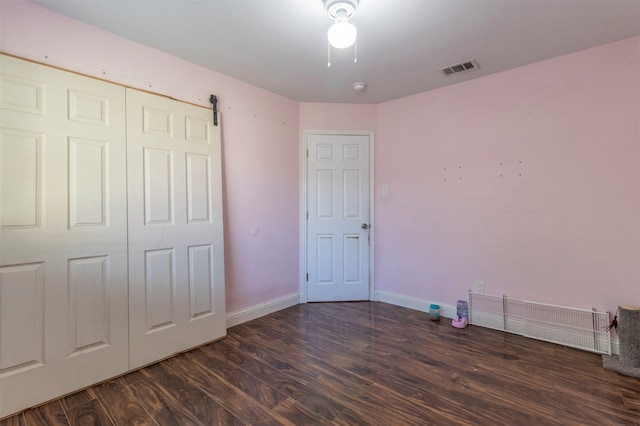 unfurnished bedroom featuring dark hardwood / wood-style floors and a closet