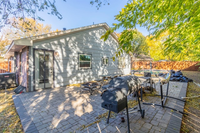 rear view of house featuring central air condition unit and a patio