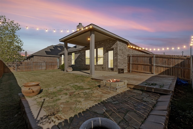 exterior space with a wooden deck, a yard, and an outdoor fire pit