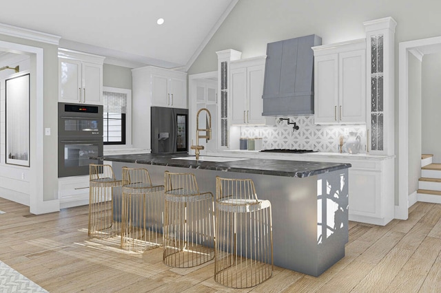 kitchen featuring a breakfast bar, white cabinets, and light hardwood / wood-style flooring