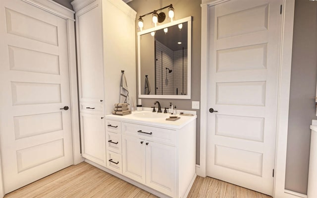 bathroom featuring walk in shower, vanity, and hardwood / wood-style flooring