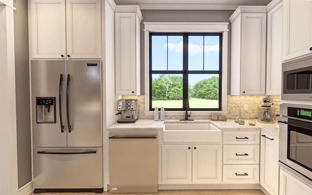 kitchen with appliances with stainless steel finishes, backsplash, a wealth of natural light, and sink