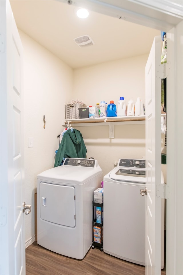 clothes washing area featuring washer and dryer and wood-type flooring