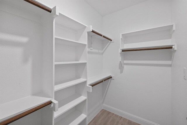 walk in closet with light hardwood / wood-style flooring