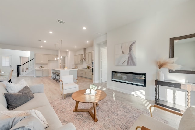 living room with sink and light hardwood / wood-style floors