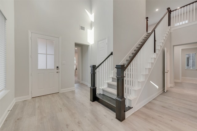 foyer entrance featuring a high ceiling and light wood-type flooring