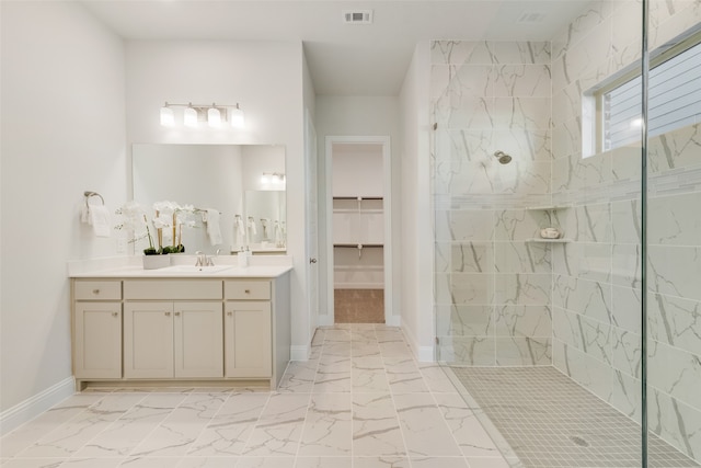 bathroom featuring tiled shower and vanity