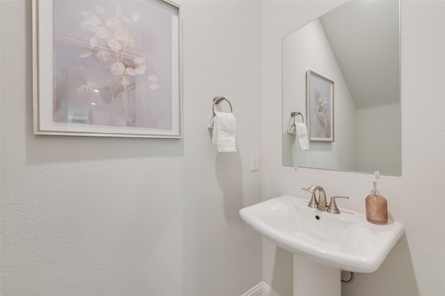 bathroom featuring sink and vaulted ceiling